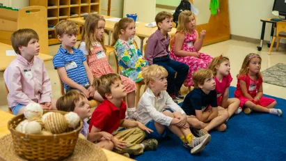 A dozen children sit cross-legged and in chairs, attentively learning Jesus' teachings in one of St. Luke's Sunday School classrooms.