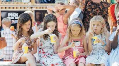 Kids sit around in St. Luke's Sunday School eating snow cones on a fun day outside.
