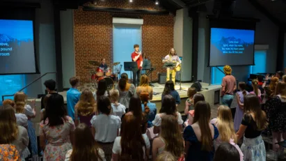 A band led by students plays for the assembled Student Ministry of 6th-12th graders, fostering fellowship and spiritual development.