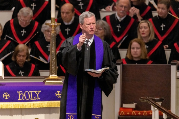 Dr. Tom Pace delivers a sermon during St. Luke's Traditional 11:00 a.m. worship service. He holds his bible while using his thumb to illustrate his point.