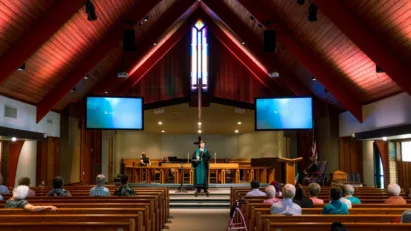 A reverend of St. Luke's delivers a Sermon in Gethsemane, a beautiful wood accented worship space that is St. Luke's sister campus.