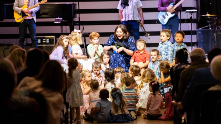 Lori Fahrbach delivers the children's message during St. Luke's Contemporary worship service. She sits on the steps leading to the stage, while kids surround her to participate.